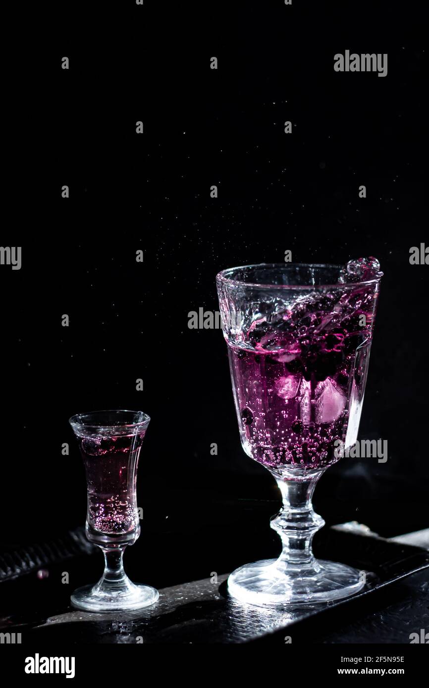 Boisson aux baies. Photographie sombre. Mise au point de l'avant du verre. Banque D'Images