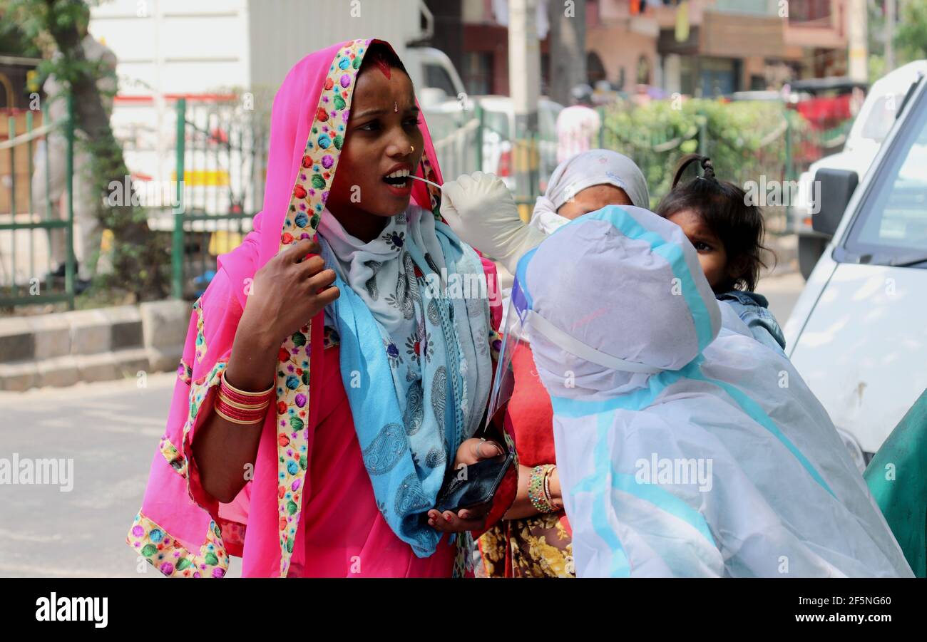 Un professionnel de la santé portant un équipement de protection individuelle (EPI) recueille des échantillons d'écouvillons auprès d'une femme pour le test Covid-19 RT-PCR sur les routes à New Delhi.Top les responsables des Nations Unies, y compris le chef du maintien de la paix de l'ONU, ont exprimé leur gratitude à l'Inde pour son don de 200,000 doses de vaccin COVID 19 pour le maintien de la paix. L'Inde a enregistré 62,258 nouvelles infections à coronavirus en 24 heures, la plus forte augmentation d'une journée jusqu'à présent cette année. Selon la CIMR, 23, 97, 69,553 échantillons ont été testés jusqu'au 26 mars 2021 et 11, 64,915 échantillons ont été testés vendredi. (Photo de Naveen Sharma/SOPA Images/Sipa USA) Banque D'Images