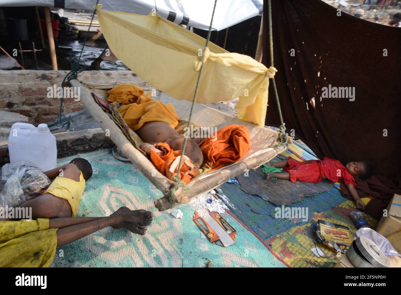 Des enfants sont vus à l'intérieur d'une tente improvisée dans des abris temporaires mis en place pour les réfugiés Rohingya déplacés des jours après un incendie dans un camp de réfugiés d'Ukhia, Banque D'Images