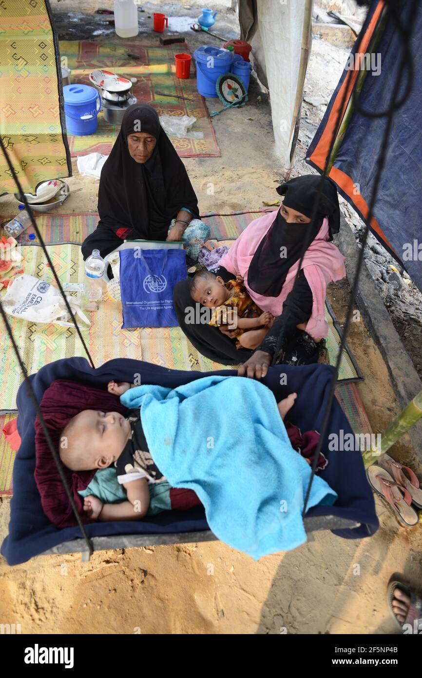 Les femmes et ses enfants sont vus à l'intérieur d'une tente improvisée Parmi les abris temporaires mis en place pour les journées des réfugiés de Rohingya déplacés après un incendie à un réfugié Banque D'Images