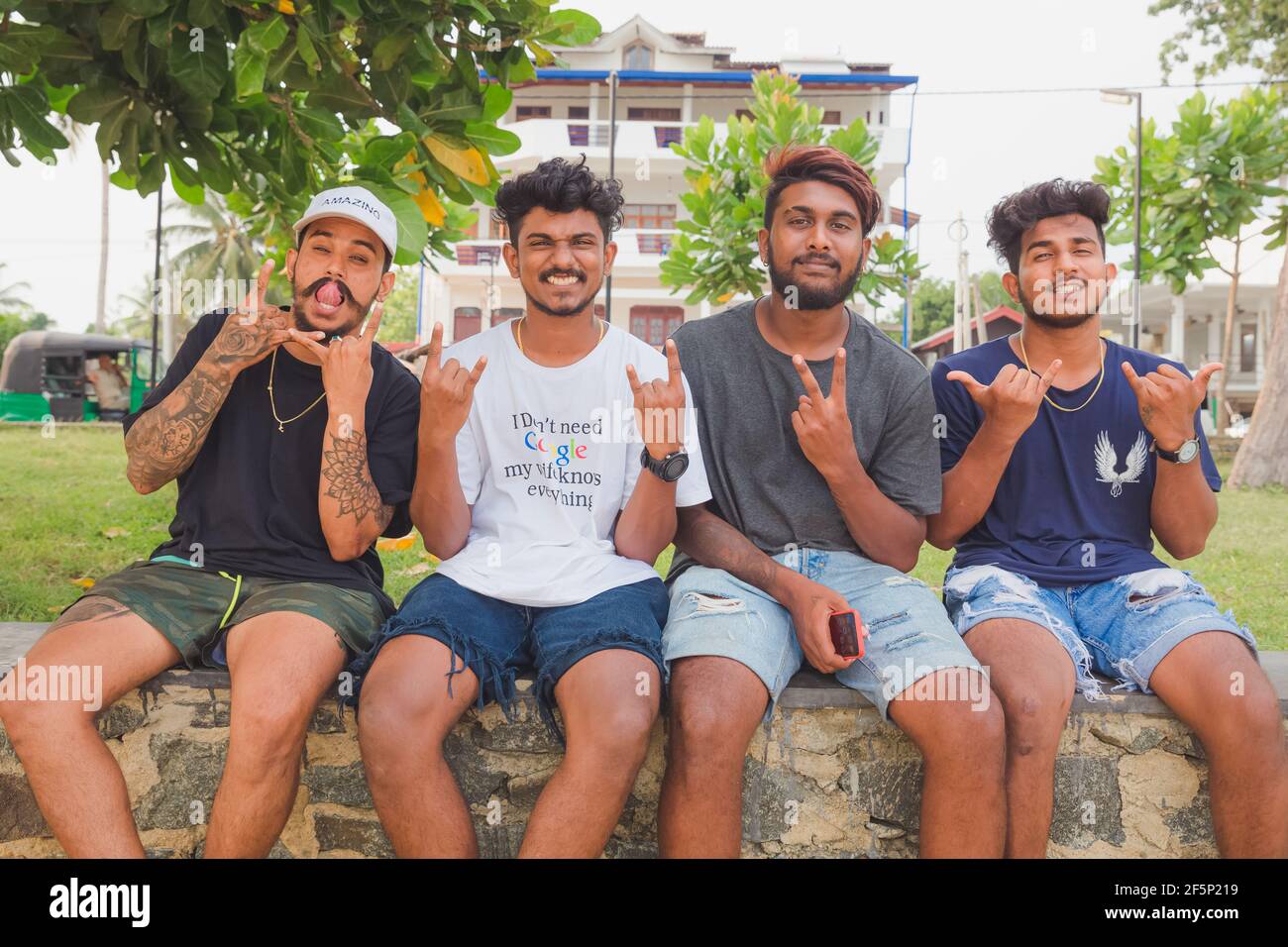 Weligama, Sri Lanka - Mars 28 2019: Le jeune surfeur sud-asiatique dude geste à la caméra tout en traînant à la plage de Weligama, Sri Lanka. Banque D'Images