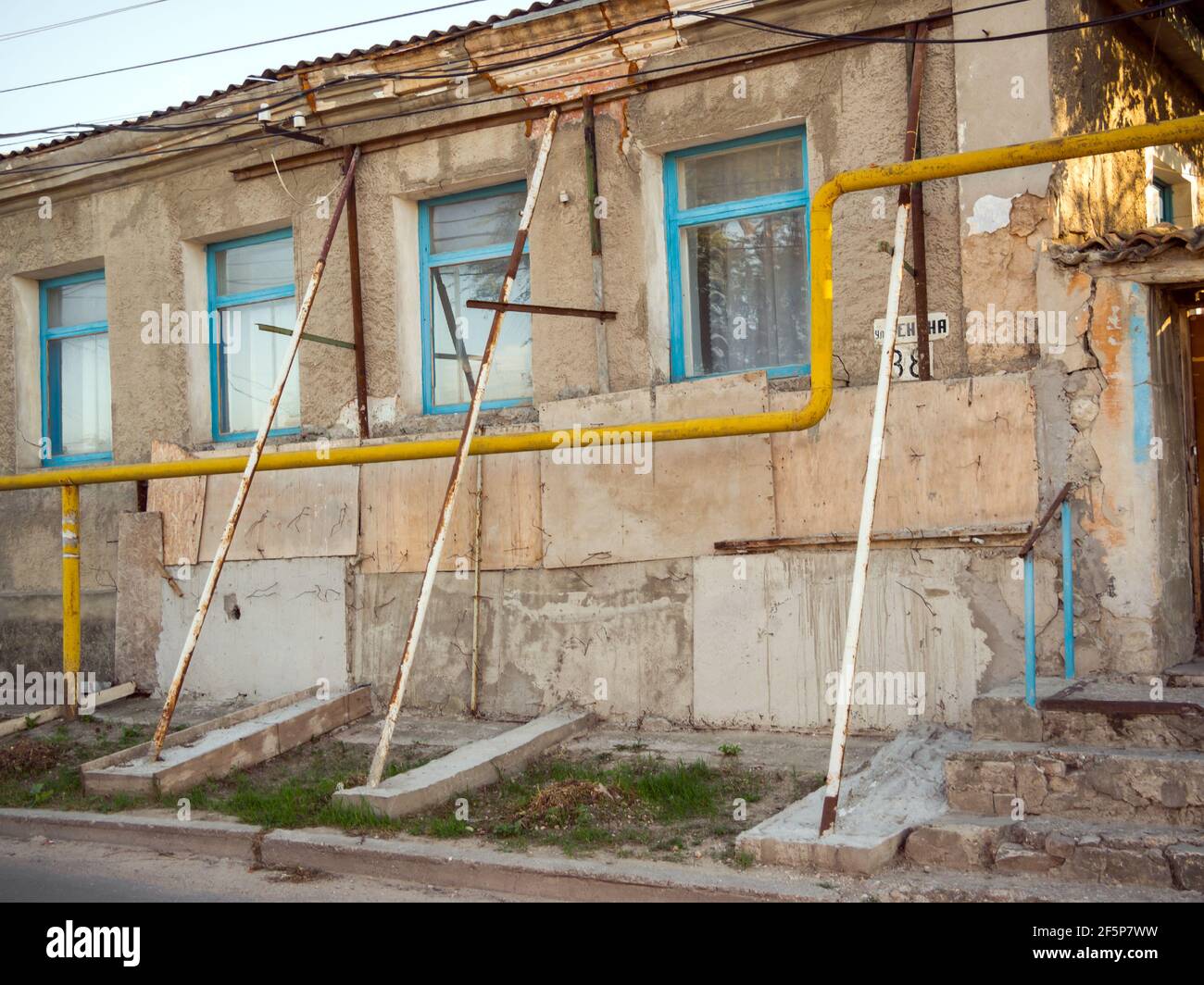 Feodosiya, Crimée - 15 septembre 2020 : supports de tuyaux soutenant la façade d'une ancienne maison Banque D'Images