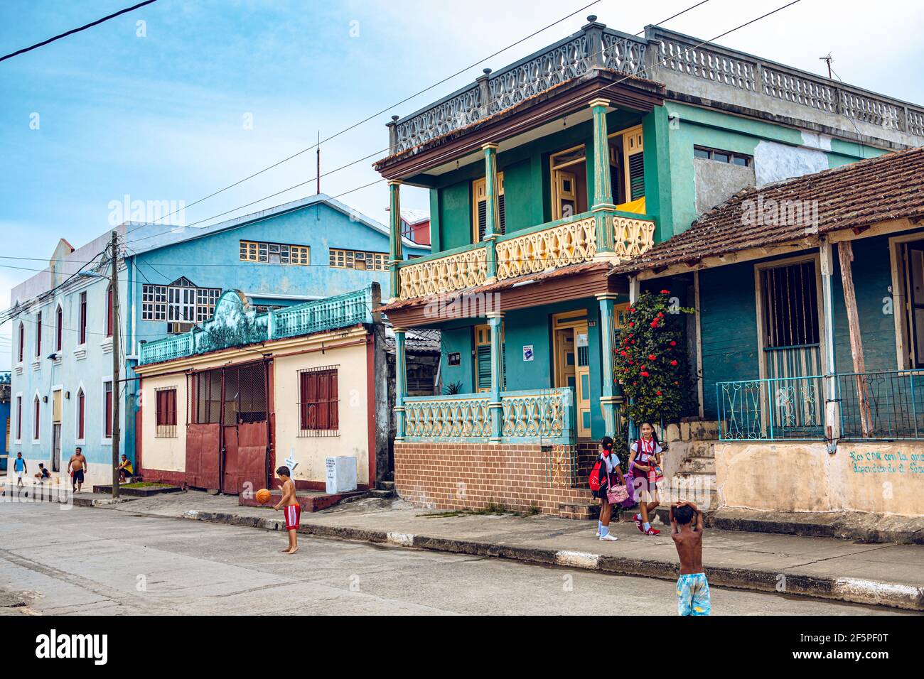 Baracoa, Cuba - 25 octobre 2019 : les enfants cubains jouent dans la rue avec des maisons traditionnelles colorées - sensation de l'esprit du vrai Cuba Banque D'Images
