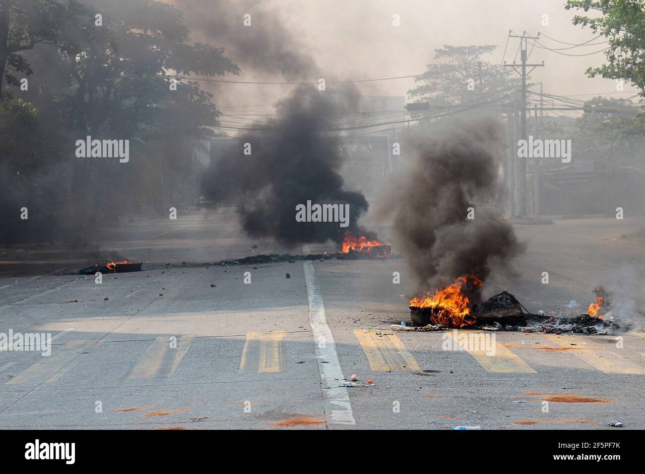 Des pneus en feu vus au milieu de la rue pour empêcher la police et l'armée d'atteindre les manifestants anti-démocratie lors d'une manifestation contre le coup d'État militaire.la police et les militaires du Myanmar (tatmadow) ont attaqué les manifestants avec des balles en caoutchouc, des munitions réelles, Des gaz lacrymogènes et des bombes lacrymogènes en réponse aux manifestants anti-coup d'État militaire samedi, tuant plus de 90 personnes et en blessant beaucoup d'autres. Au moins 300 personnes ont été tuées au Myanmar depuis le coup d'État du 1er février, a déclaré un responsable des droits de l'homme de l'ONU. Le conseiller militaire du Myanmar en détention d'État, Aung San Suu Kyi, le mois de février Banque D'Images