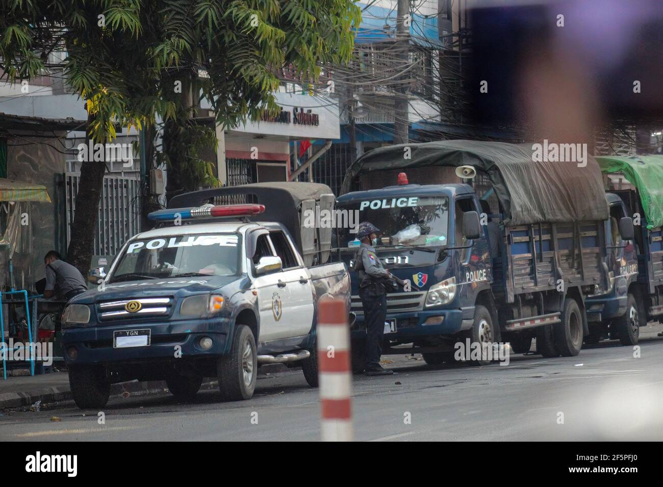 Des camions de police sont stationnés dans la rue lors d'une manifestation contre le coup d'État militaire.la police et les militaires du Myanmar (tatmadow) ont attaqué les manifestants avec des balles en caoutchouc, des munitions réelles, des gaz lacrymogènes et des bombes lacrymogènes en réponse aux manifestants anti-coup d'État militaire de samedi, tuant plus de 90 personnes et en blessant beaucoup d'autres. Au moins 300 personnes ont été tuées au Myanmar depuis le coup d'État du 1er février, a déclaré un responsable des droits de l'homme de l'ONU. L'armée du Myanmar a détenu le conseiller d'État du Myanmar Aung San Suu Kyi le 01 février 2021 et a déclaré l'état d'urgence tout en prenant le pouvoir Banque D'Images