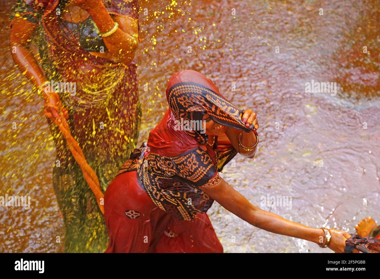 Beawar, Rajasthan, 25 mars 2016: Devar (beau-frère) jeta de l'eau colorée sur Bhabhi (beau-sœur) et les femmes battent les hommes avec des cordes comme par traditi Banque D'Images