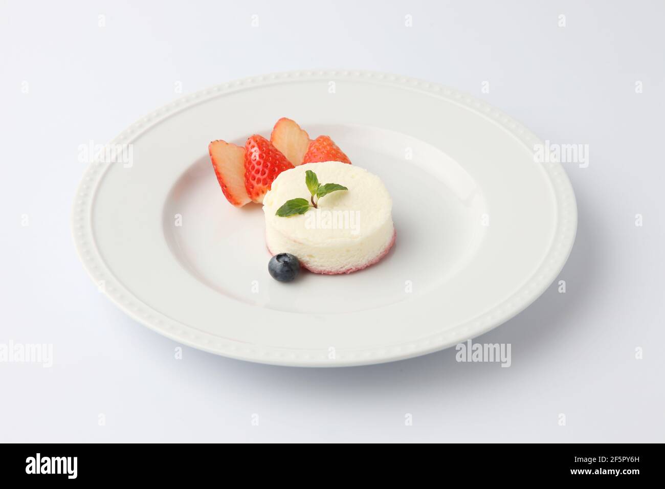 cheesecake blanc en mousseline sur plaque isolée sur fond blanc Banque D'Images