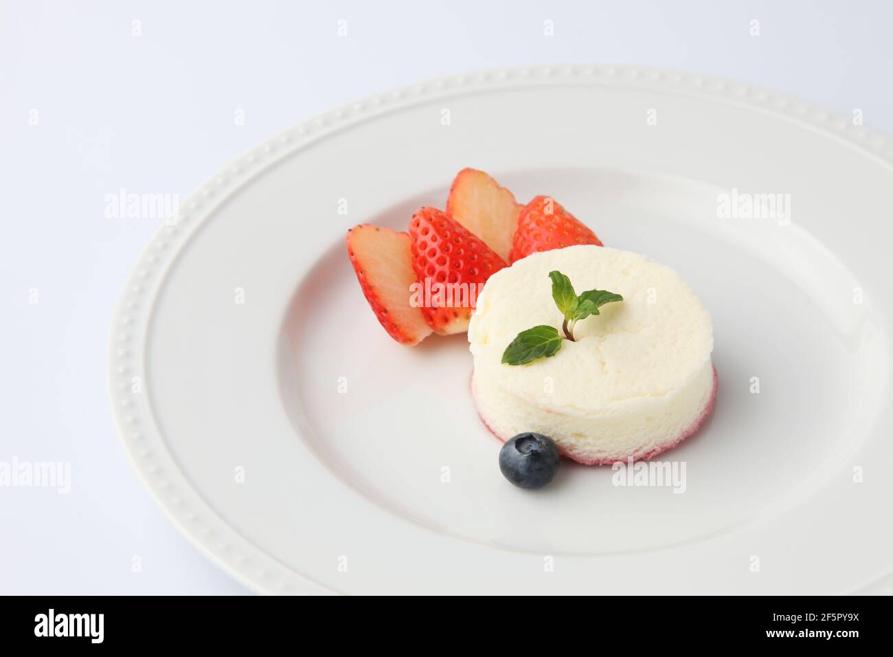 cheesecake blanc en mousseline sur plaque isolée sur fond blanc Banque D'Images