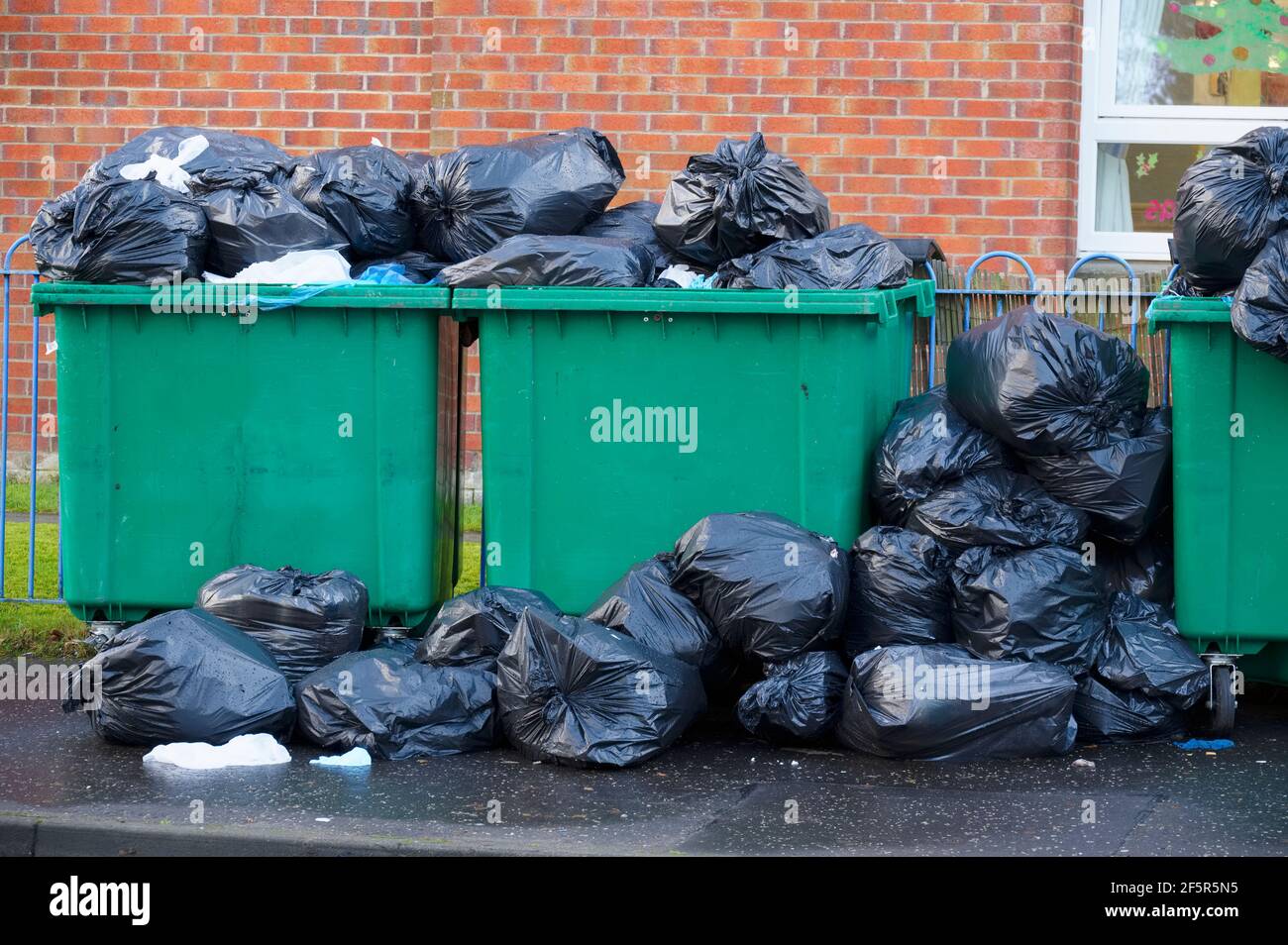 Envolez-vous pour le basculement des déchets et des sacs poubelle noirs dans un quartier résidentiel Banque D'Images