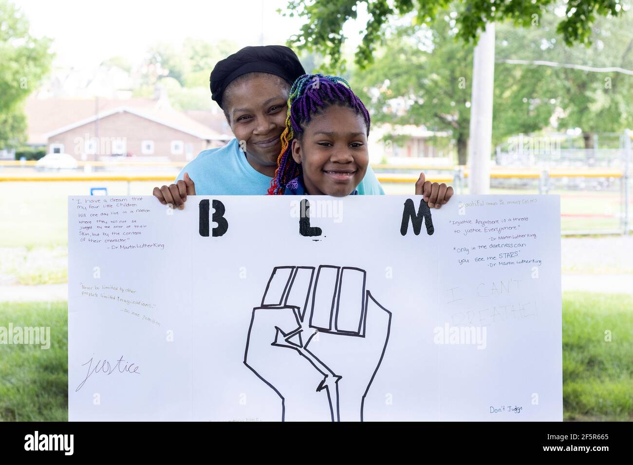 La mère et la fille afro-américaines à BLM les vies noires comptent Proteste au parc de la ville avec une affiche Banque D'Images