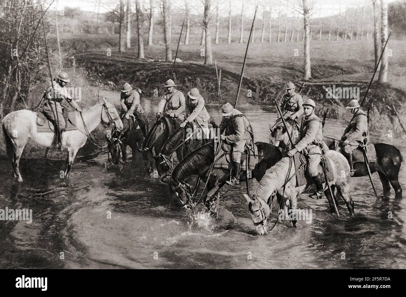 WWI - Dragoons français arroser leurs chevaux près de l'avant. Ils étaient considérés comme l'une des plus belles unités de cavalerie de l'époque. Les Dragoons étaient à l'origine une classe d'infanterie montée, qui s'est déportée de leurs chevaux pour se battre à pied. Dès le début du XVIIe siècle, les dragons étaient employés comme cavalerie conventionnelle et entraînés au combat avec des épées ou des lances et des armes à feu tout en restant à cheval. Le nom de dragoon est dérivé d'un type d'arme à feu, appelé un dragon, qui était une version pistolet d'un blunderbuss.l'Armée française moderne conserve trois régiments de dragons de l'original 32 de la première Guerre mondiale Banque D'Images