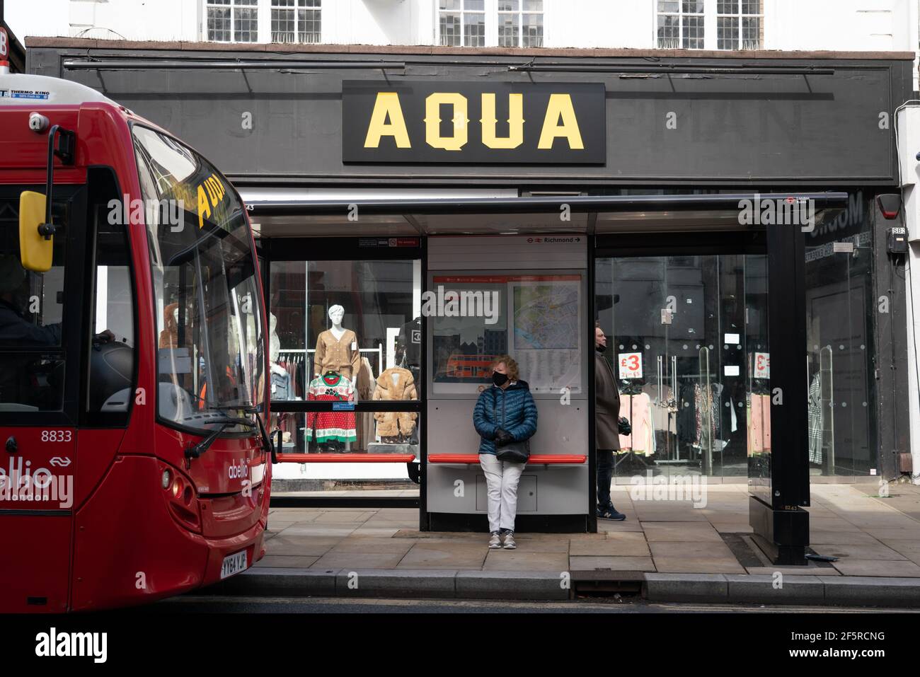 Femme à un arrêt de bus Banque D'Images