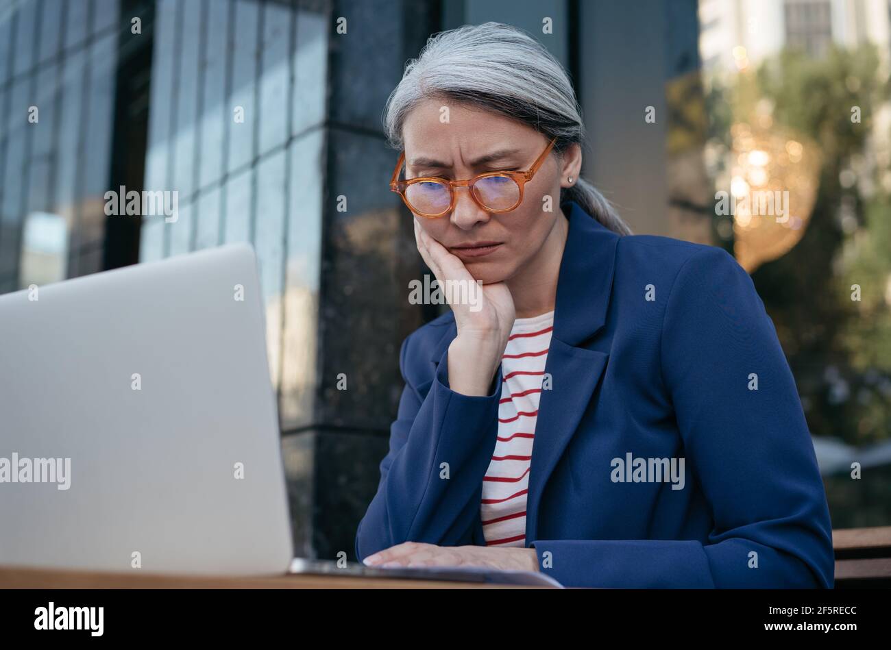 Femme d'affaires asiatique fatiguée travaillant projet, utilisant un ordinateur portable, recherche d'informations. Portrait d'une femme mûre frustrée assise sur le lieu de travail Banque D'Images