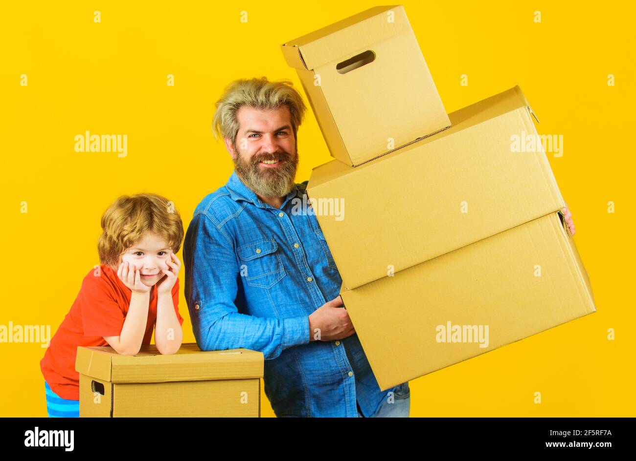 Livraison et temps de famille. Joyeux fils et père avec boîte en carton. Banque D'Images