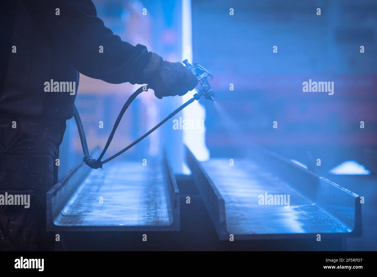 Homme avec gants peinture et laquage de l'acier avec compresseur Banque D'Images