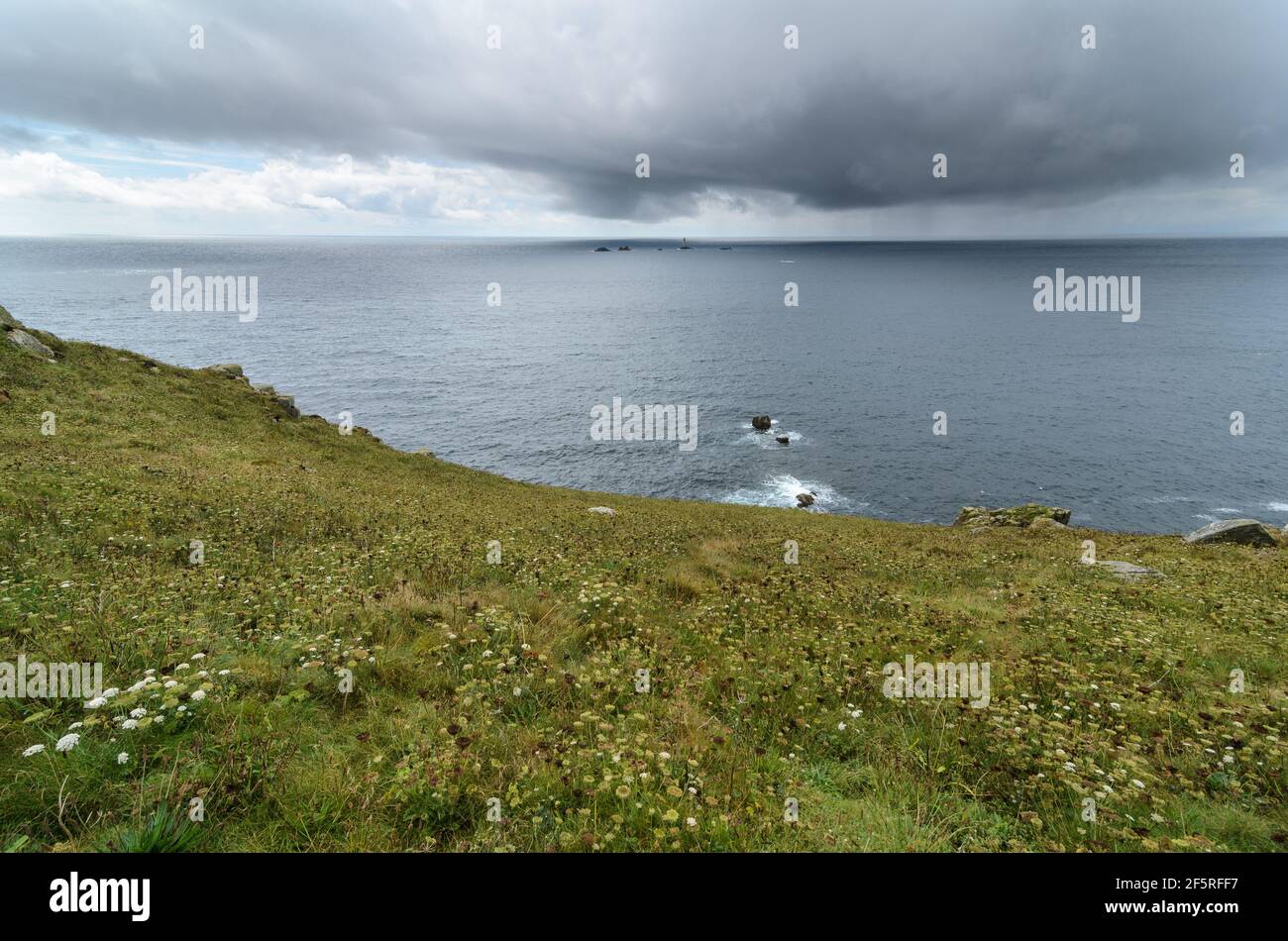 Un jour pluvieux et orageux avec vue sur l'Atlantique en direction du phare de Longships depuis la fin de Land à Cornwall, en Angleterre. Banque D'Images