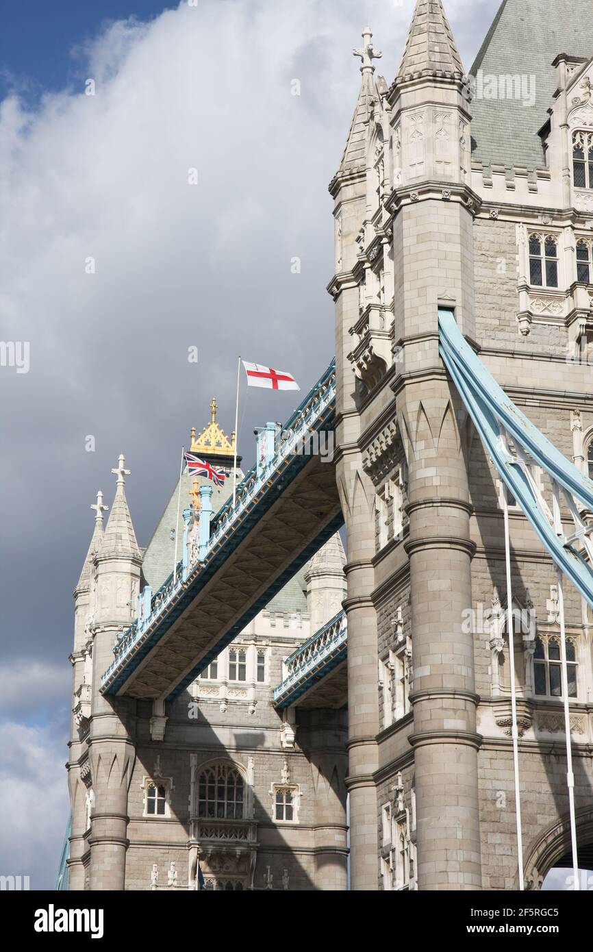 Vue basse sur British Flags survolant Tower Bridge Banque D'Images