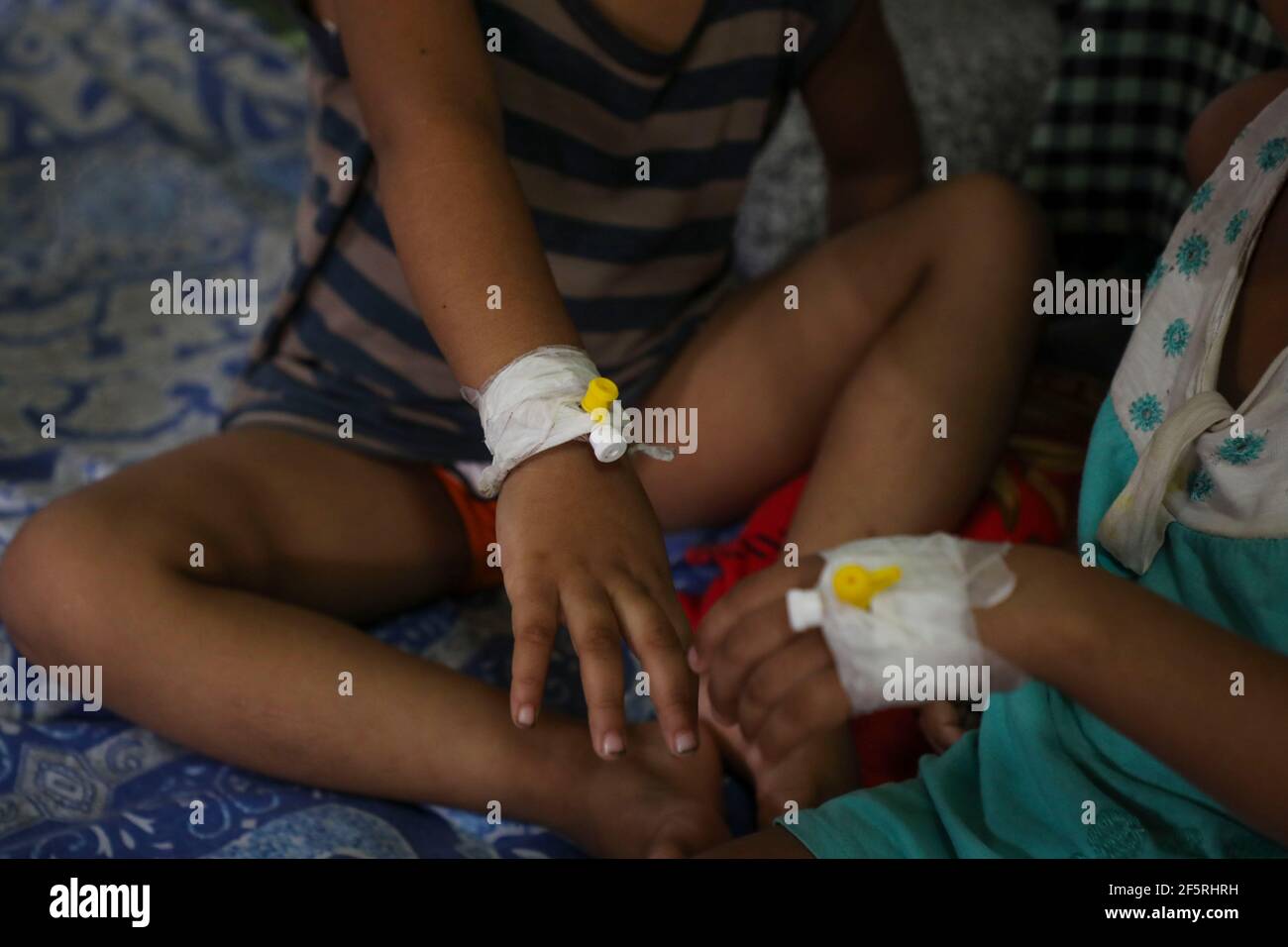 Mains avec une canule de deux enfants, patient de la dengue virale transmise par les moustiques, dans un hôpital de Dhaka, au Bangladesh Banque D'Images