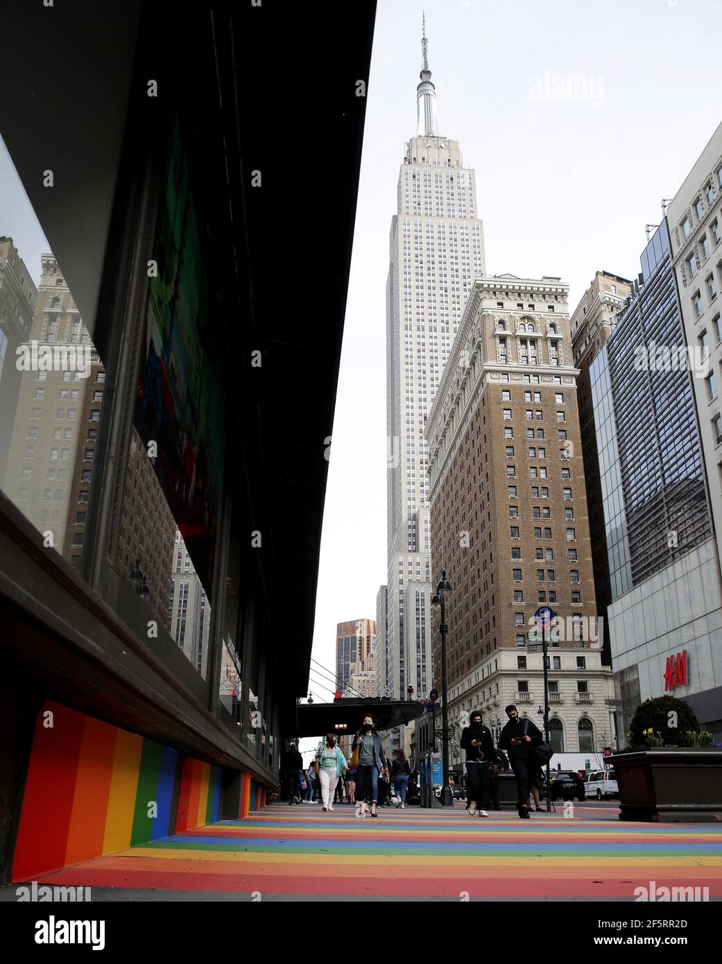 New York, États-Unis. 27 mars 2021. Des piétons marchent sur le trottoir couvert des couleurs de l'arc-en-ciel à New York le samedi 27 mars 2021. Pour célébrer une collaboration colorée entre les marques classiques Lacoste et Polaroid, le trottoir extérieur de Macy's a des bandes arc-en-ciel inspirées du célèbre logo arc-en-ciel de Polaroid de son premier film couleur instantané. Photo de John Angelillo/UPI crédit: UPI/Alay Live News Banque D'Images