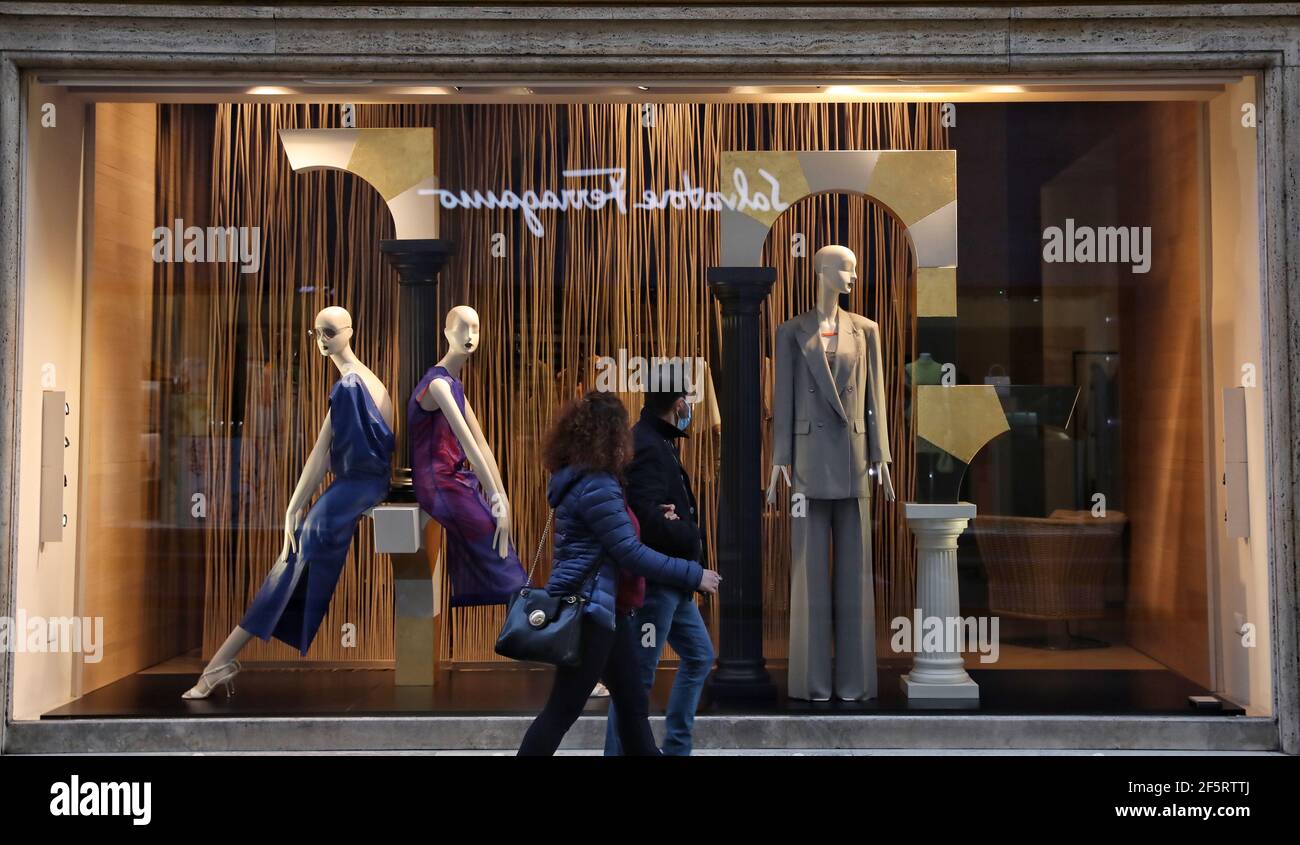 Rome, Italie. 27 mars 2021. La marche des gens passe un magasin fermé à Rome, Italie, le 27 mars 2021. Selon les dernières données du ministère de la Santé, 23,839 nouveaux cas ont été enregistrés quotidiennement, ce qui a porté le total du pays à 3,512,453, comprenant des infections actives, des reprises et des décès, depuis que la pandémie a officiellement éclaté ici à la fin de février de l'année dernière. Credit: Cheng Tingting/Xinhua/Alay Live News Banque D'Images