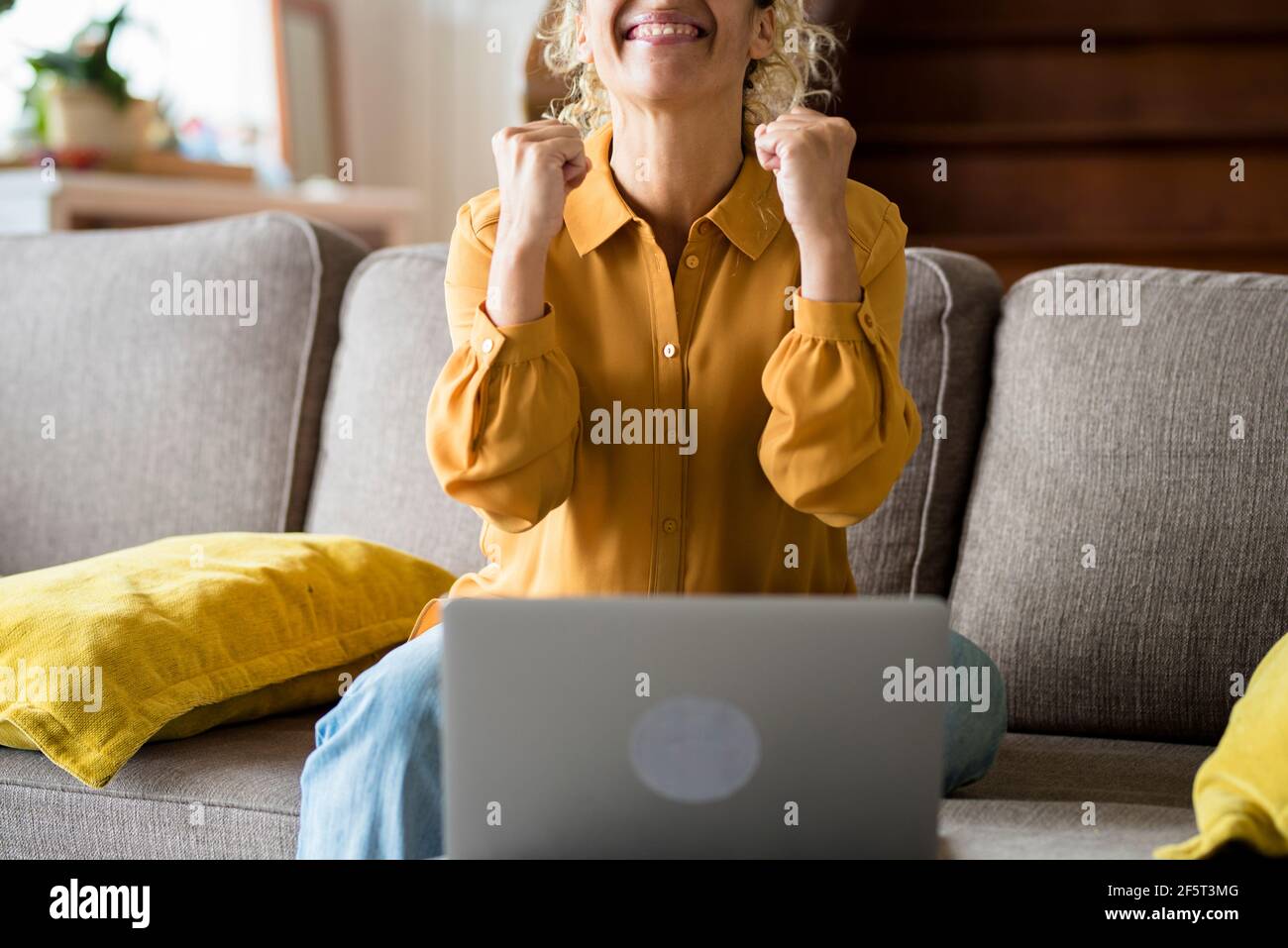 Bonne femme adulte recevoir une notification sur ordinateur portable et célébrer avec joie - les femmes à la maison apprécient la technologie en ligne - milieu surpris ag Banque D'Images