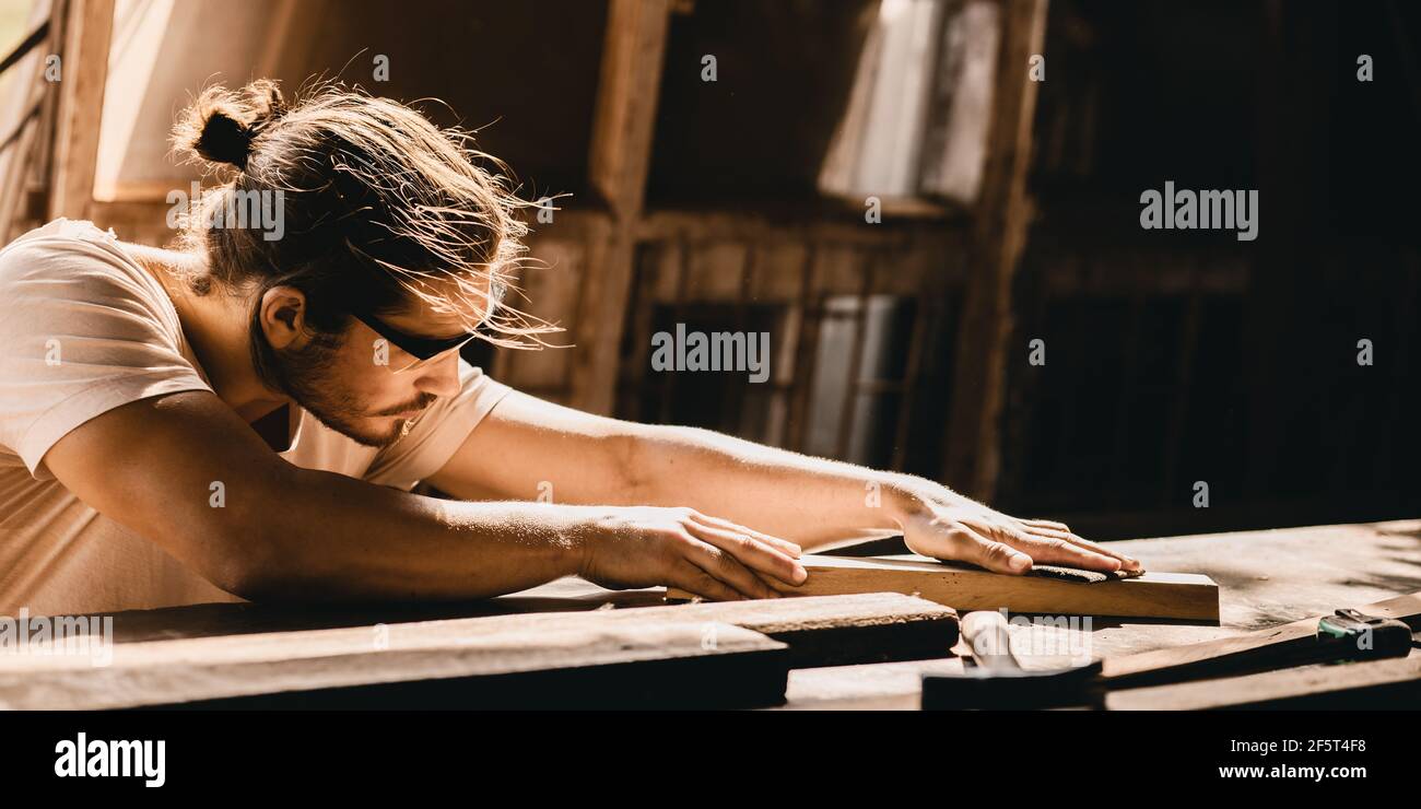 Menuisier homme professionnel qualifié dans le travail de bois regardant le détail de chef-d'œuvre woodcraft dans atelier de meubles Banque D'Images