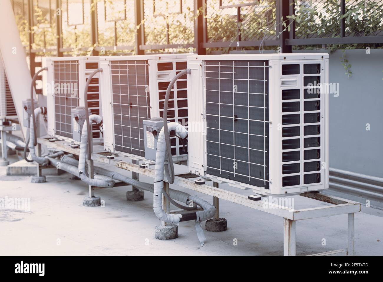 Partie chaude du compresseur de climatisation installée à l'extérieur contre la lumière du soleil Banque D'Images