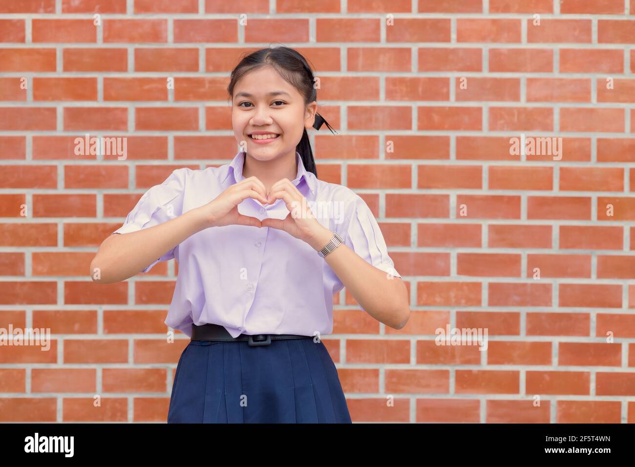 Asiatique étudiant main amour coeur signe geste Portrait heureux sourire. Banque D'Images