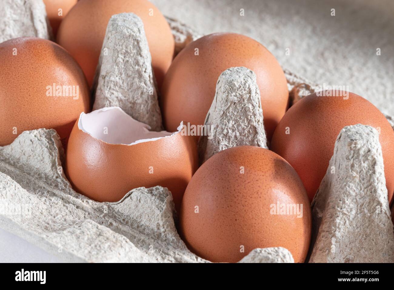 Œufs de poulet frais dans un forfait. Un œuf est cassé. Banque D'Images