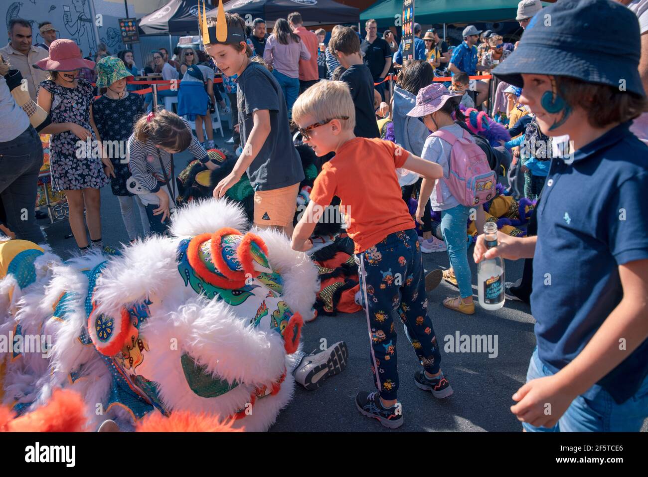(210328) -- WELLINGTON, le 28 mars 2021 (Xinhua) -- les enfants jouent pendant le festival d'art et de musique de plein air CubaDupa à Wellington, Nouvelle-Zélande, le 27 mars 2021. Le quartier de Cuba Street dans la capitale de la Nouvelle-Zélande est venu en vie au cours du week-end, tandis que les danses de lion chinois et la musique traditionnelle chinoise ornaient le plus grand festival d'art et de musique de plein air de Nouvelle-Zélande CubaDupa. L'événement a été forcé de pivoter en 2019 vers une version hors-rue en raison des tragédies de la mosquée de Christchurch, et en 2020, il a été impossible de procéder en raison des restrictions de verrouillage de la COVID-19. Cependant, le CubaDupa 2021 est revenu avec Banque D'Images