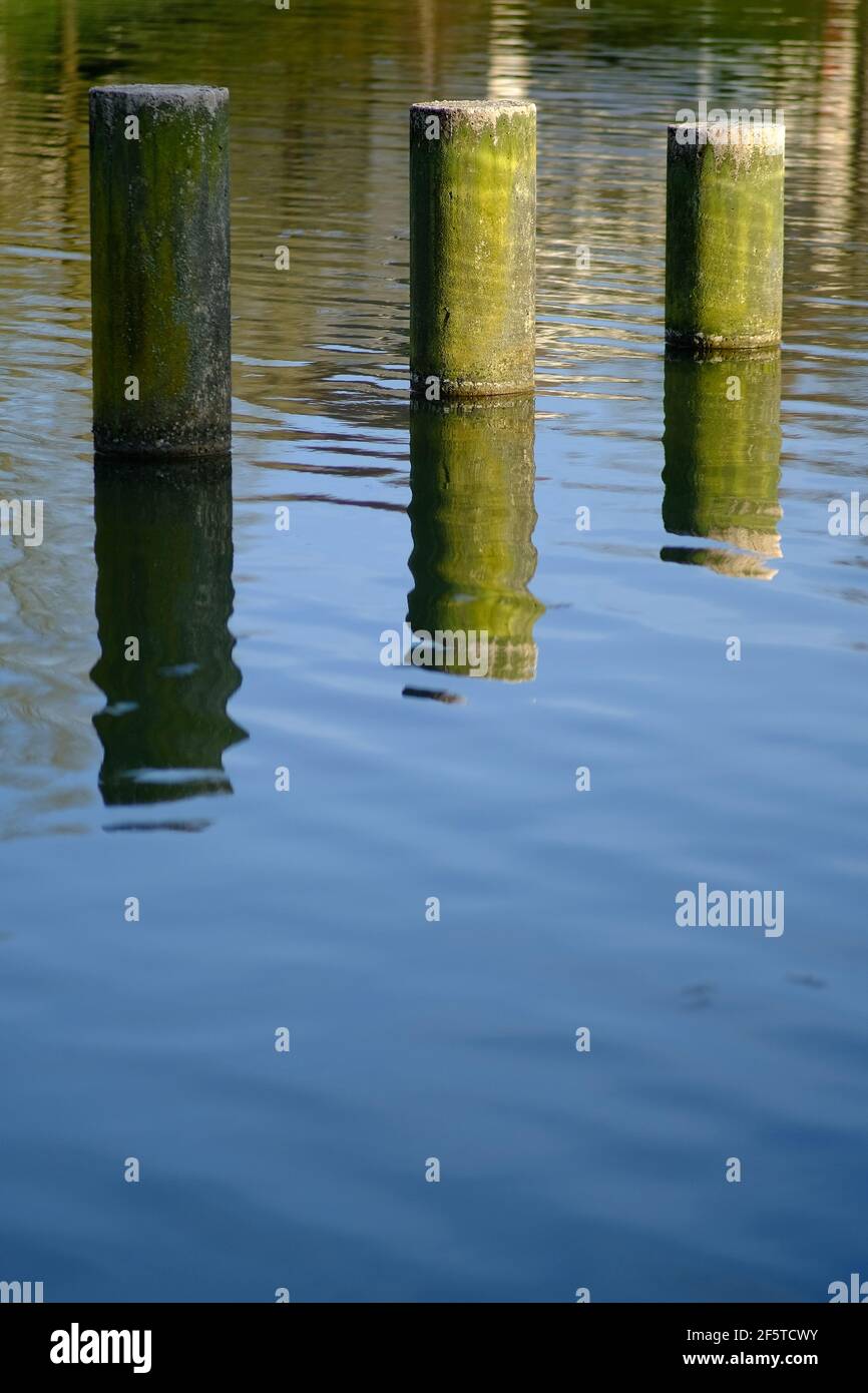 Gros plan de la réflexion de l'eau des colonnes installées dans un lac en France Banque D'Images