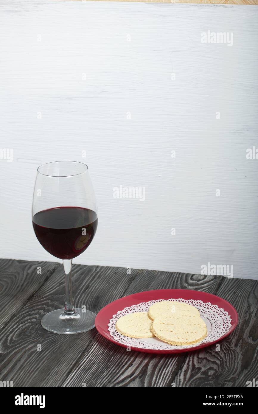 Un verre de vin rouge sec et du pain sans levain sur une assiette. Célébration de la Cène du Seigneur. Banque D'Images
