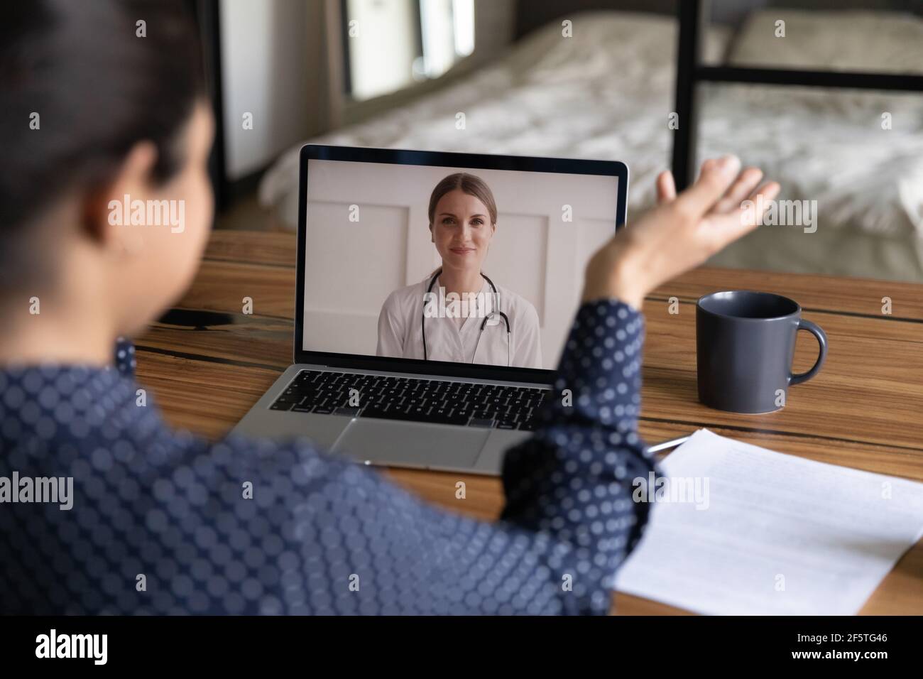 Vue arrière femme indienne effectuant un appel vidéo au médecin Banque D'Images