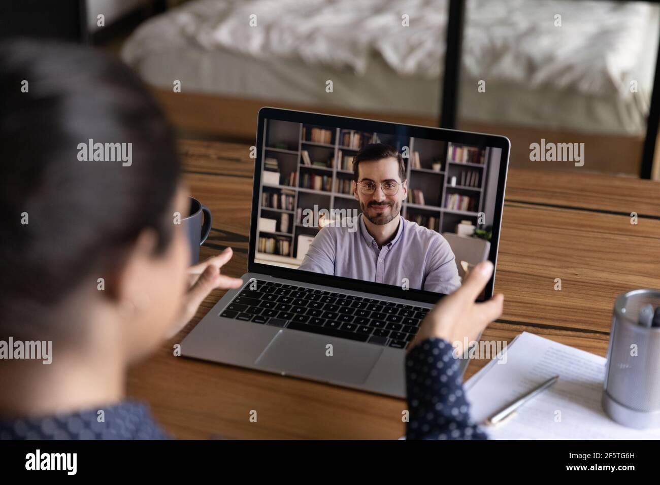 Vue arrière femme indienne effectuant un appel vidéo à un collègue Banque D'Images