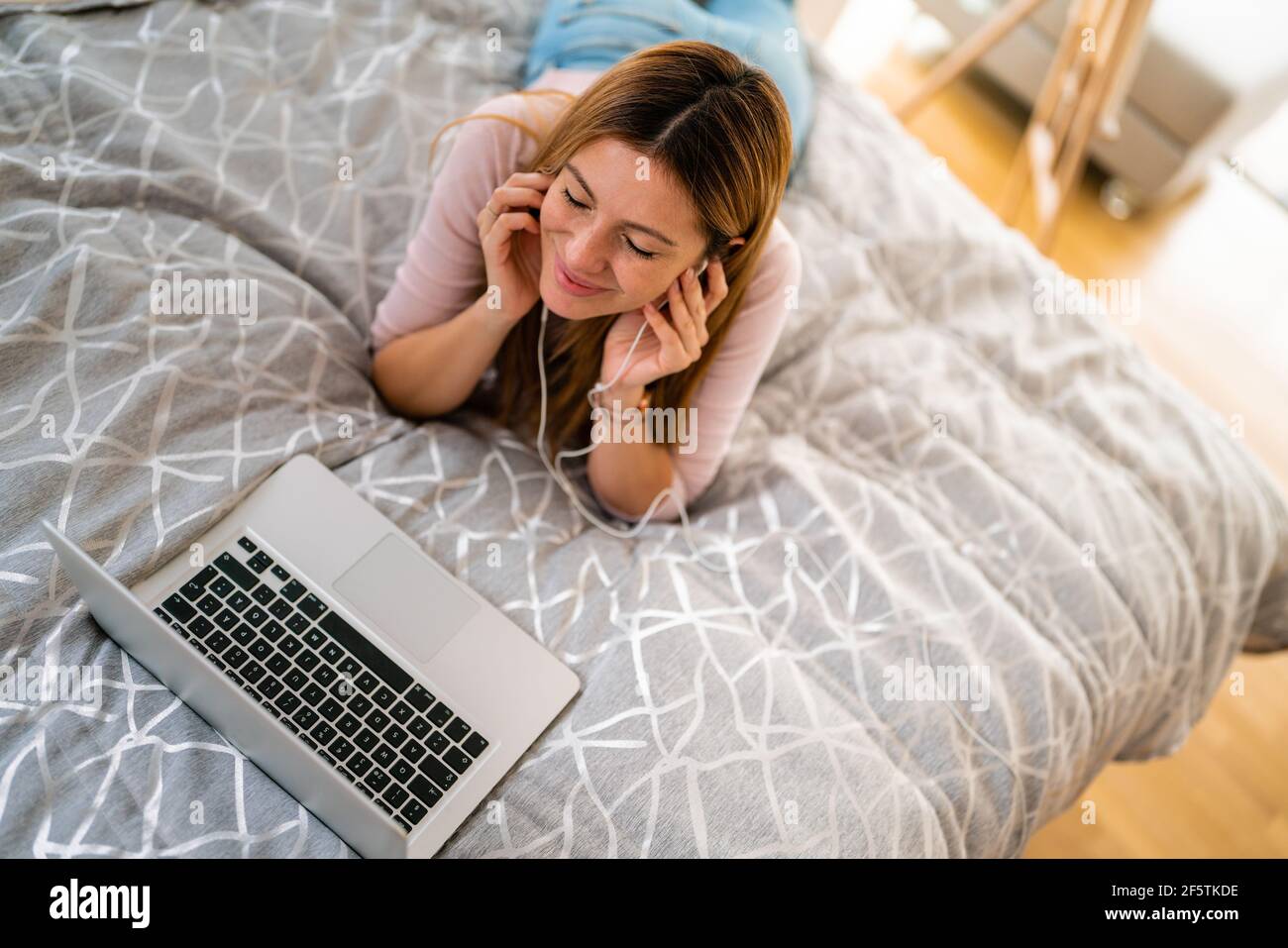 Bonne femme avec un ordinateur portable à la maison. Banque D'Images