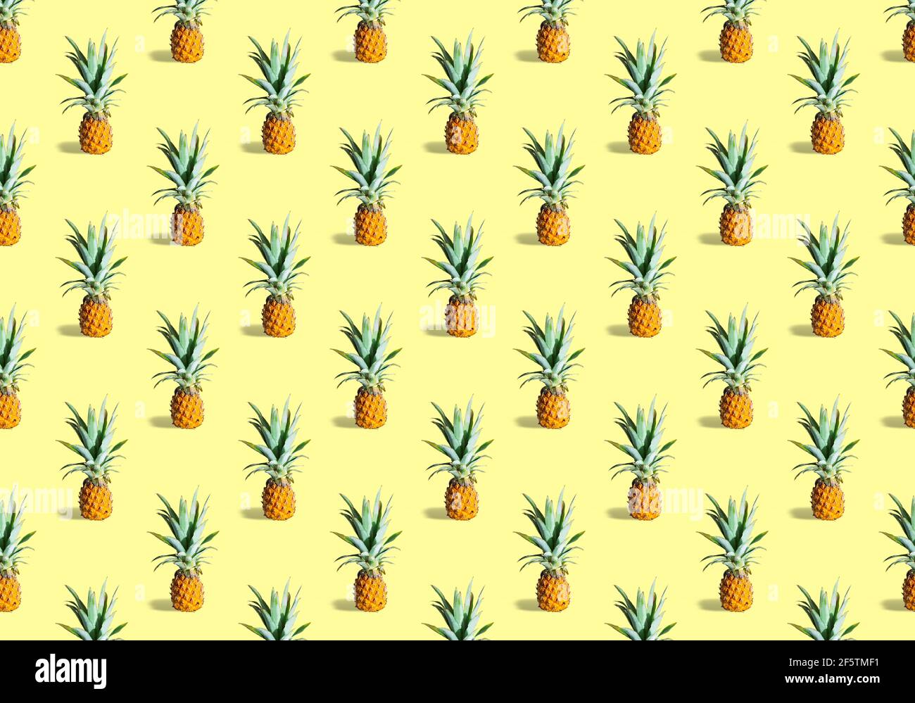 Motif sans couture de nombreuses ananas mûrs isolés sur fond jaune. Fruits tropicaux Banque D'Images