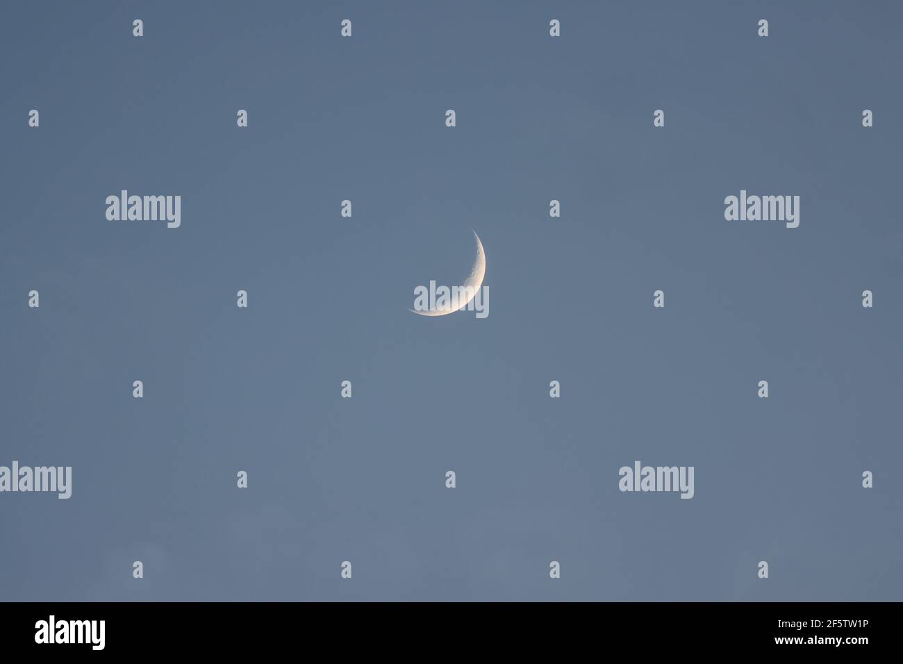 Croissant de lune cirant dans le ciel du soir Banque D'Images