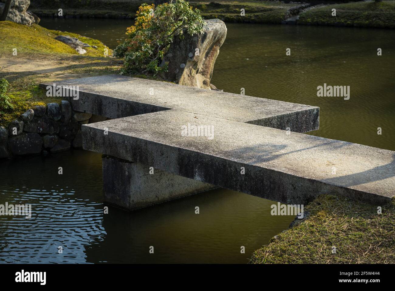 Pont géométrique en zigzag en béton au-dessus d'un étang dans un jardin japonais à Nara, Japon Banque D'Images