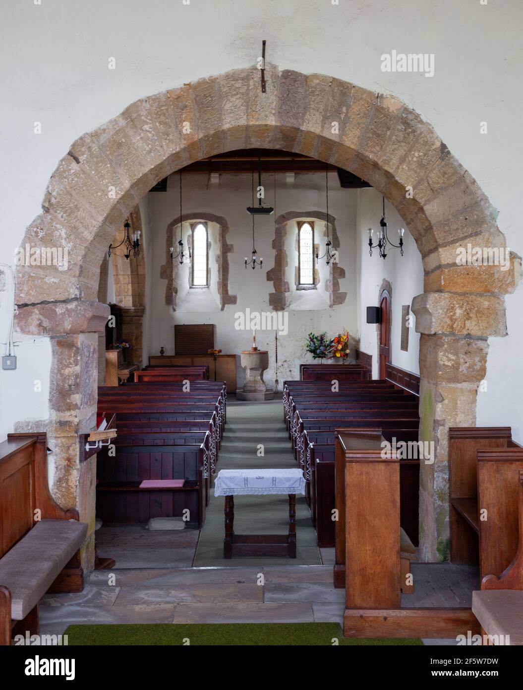 Vue intérieure à travers l'arche chancel anglo-saxonne dans la nef de l'église de tous les Saints à Ryther, dans le North Yorkshire Banque D'Images