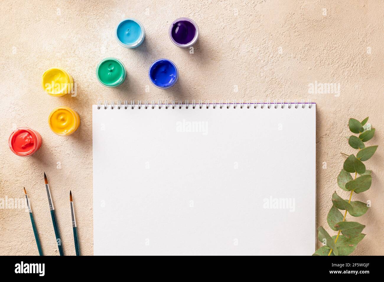 Carnet d'esquisses vierge avec pinceaux et couleurs arc-en-ciel Banque D'Images