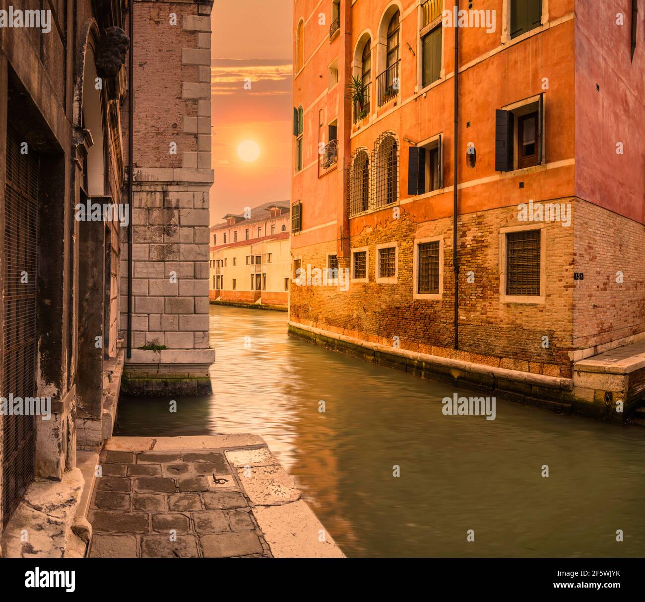 Coucher de soleil dans un canal latéral dans le secret Venise, Italie. Banque D'Images