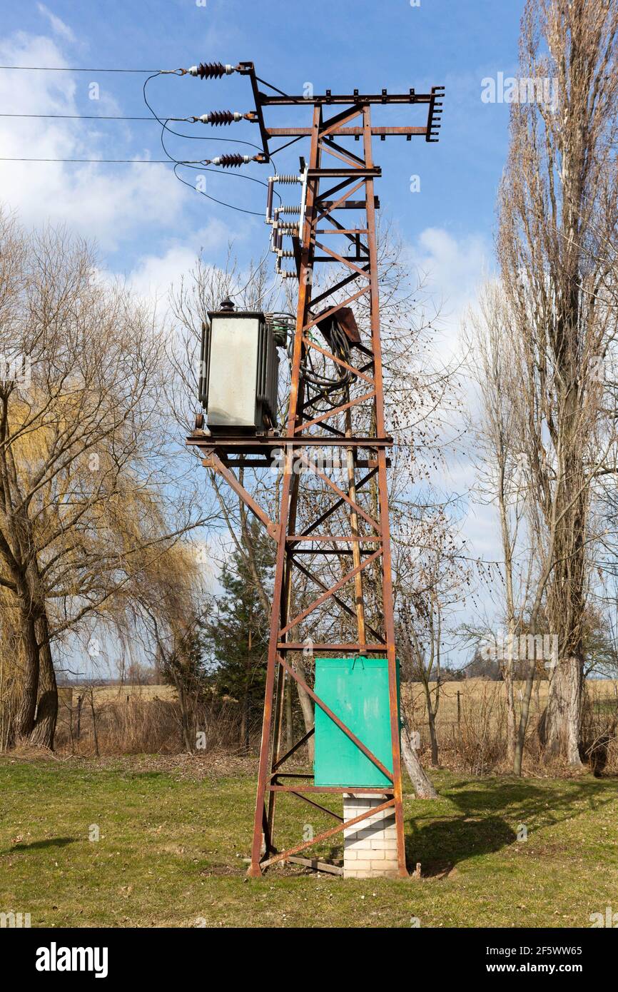 Ancien mât rouillé avec transformateur électrique Banque D'Images