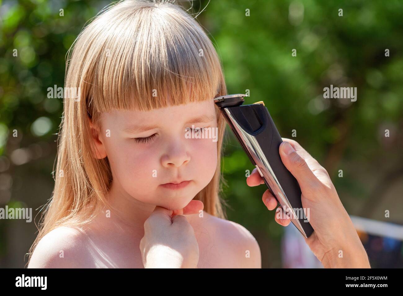 Mere Parent Coupant Les Cheveux De Sa Petite Fille A L Aide D Une Tondeuse A Cheveux Electrique Portrait En Plein Air Coupe Cheveux Electrique Amateur A Photo Stock Alamy