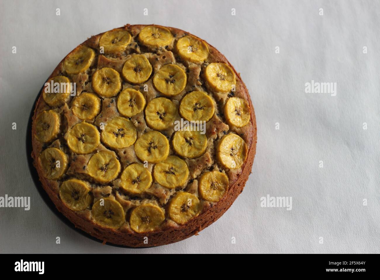 Gâteau de plantain fait maison avec des tranches de plantain comme garniture. Prise de vue sur fond blanc. Banque D'Images