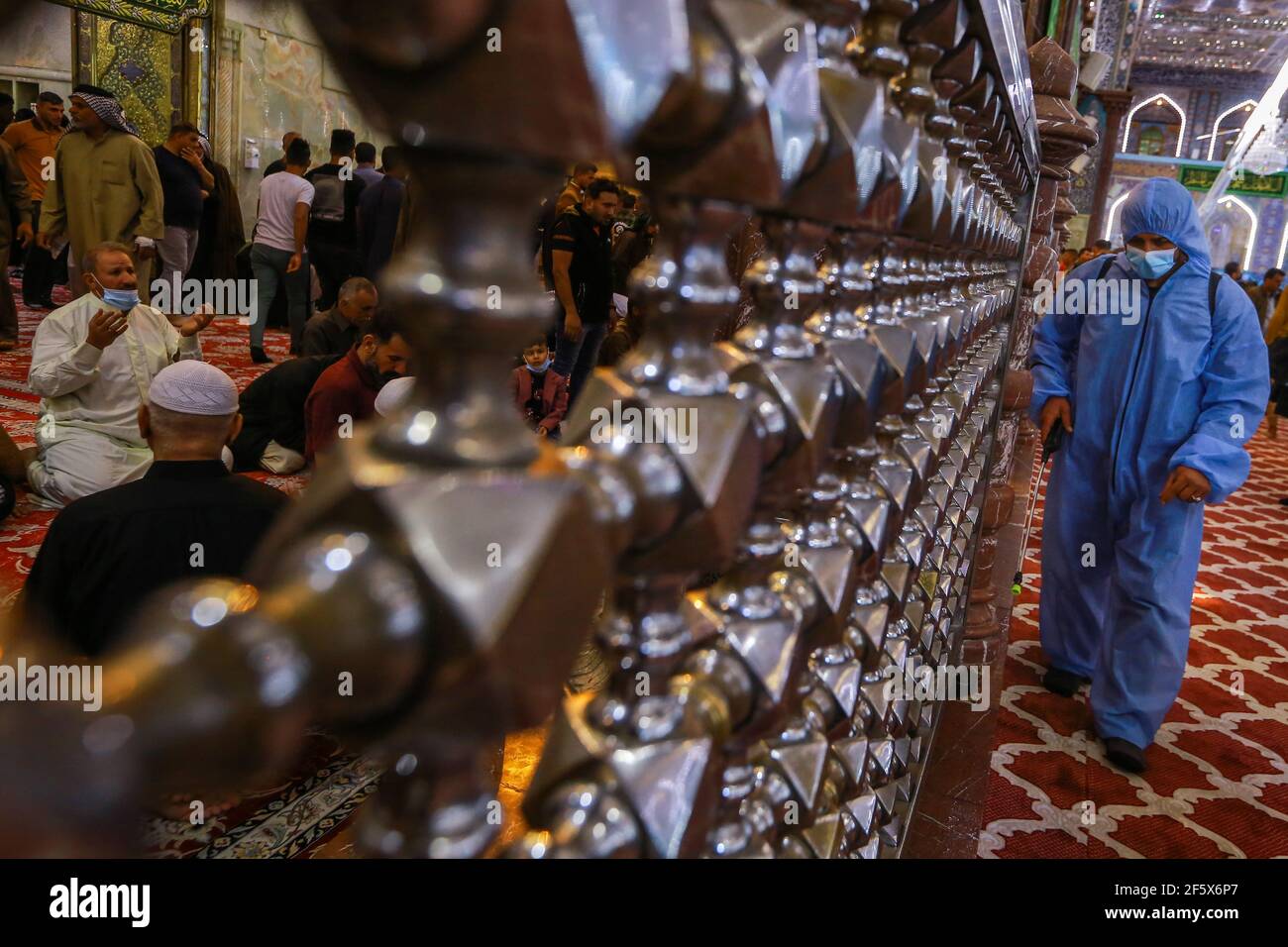 Karbala, Irak. 28 mars 2021. Un agent de santé désinfecte le sanctuaire de l'Imam Husayn lors des célébrations du Nisf de Chaban (Mid-Sha'ban). Chaque année, mi-Sha'ban est observé par les communautés musulmanes la nuit entre le 14 et le 15 de Sha'aban, qui est le huitième mois du calendrier islamique. Credit: Ameer Al Mohmedaw/dpa/Alamy Live News Banque D'Images