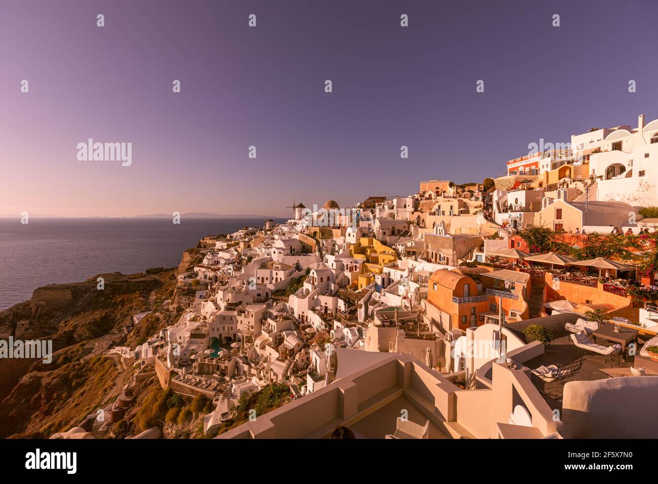 Vue imprenable sur l'île de Santorini en soirée. Pittoresque coucher de soleil sur le célèbre village de Fira, Grèce, Europe. Présentation du concept de déplacement. Artistique Banque D'Images