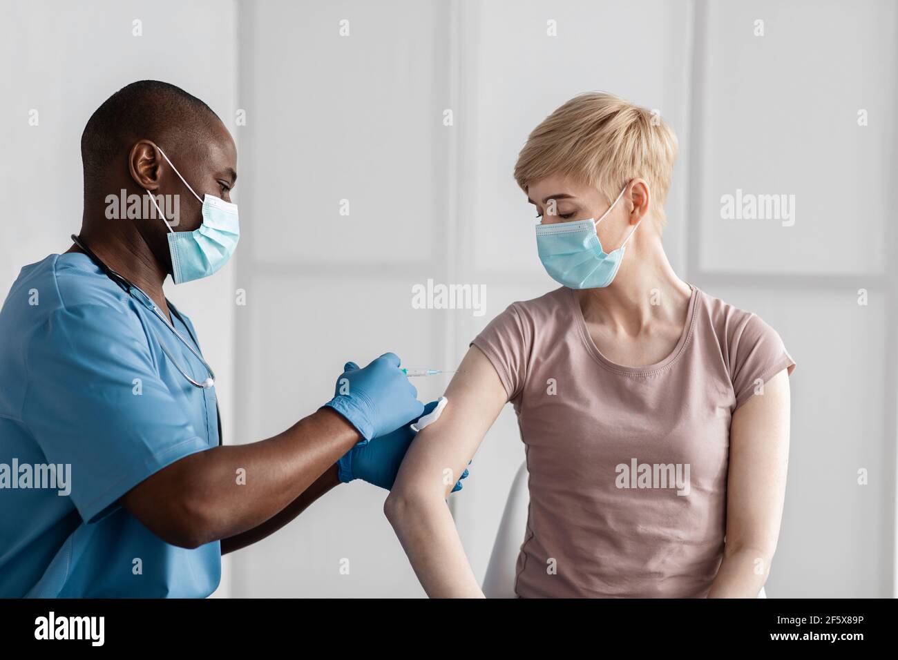 Femme dans le masque médical obtenant un vaccin antiviral à l'hôpital ou centre de santé Banque D'Images