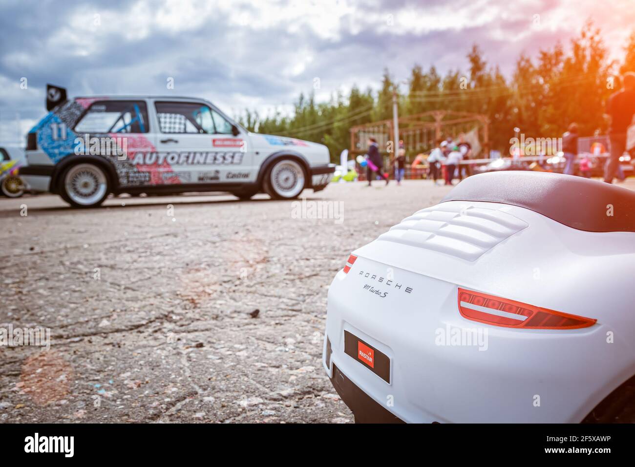 Moscou, Russie - 06 juillet 2019: Voiture-jouet Porsche 911 Carrera Turbo S dans le parking avec de vraies voitures. L'arrière de la voiture, sur le fond d'un Volkswagen Golf 2 réglé Banque D'Images