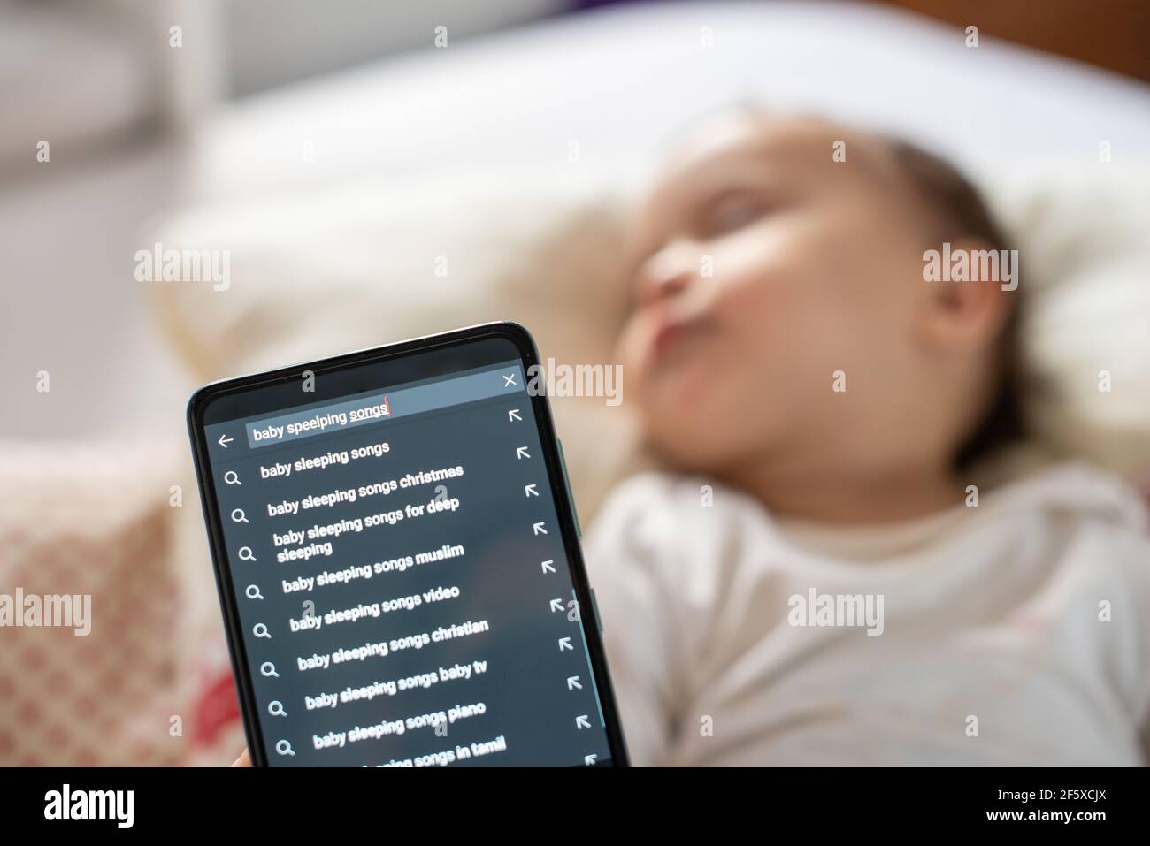 Maman Recherchant Sur Internet A L Aide De Son Telephone Pour Dormir Bebe Chansons Photo Stock Alamy