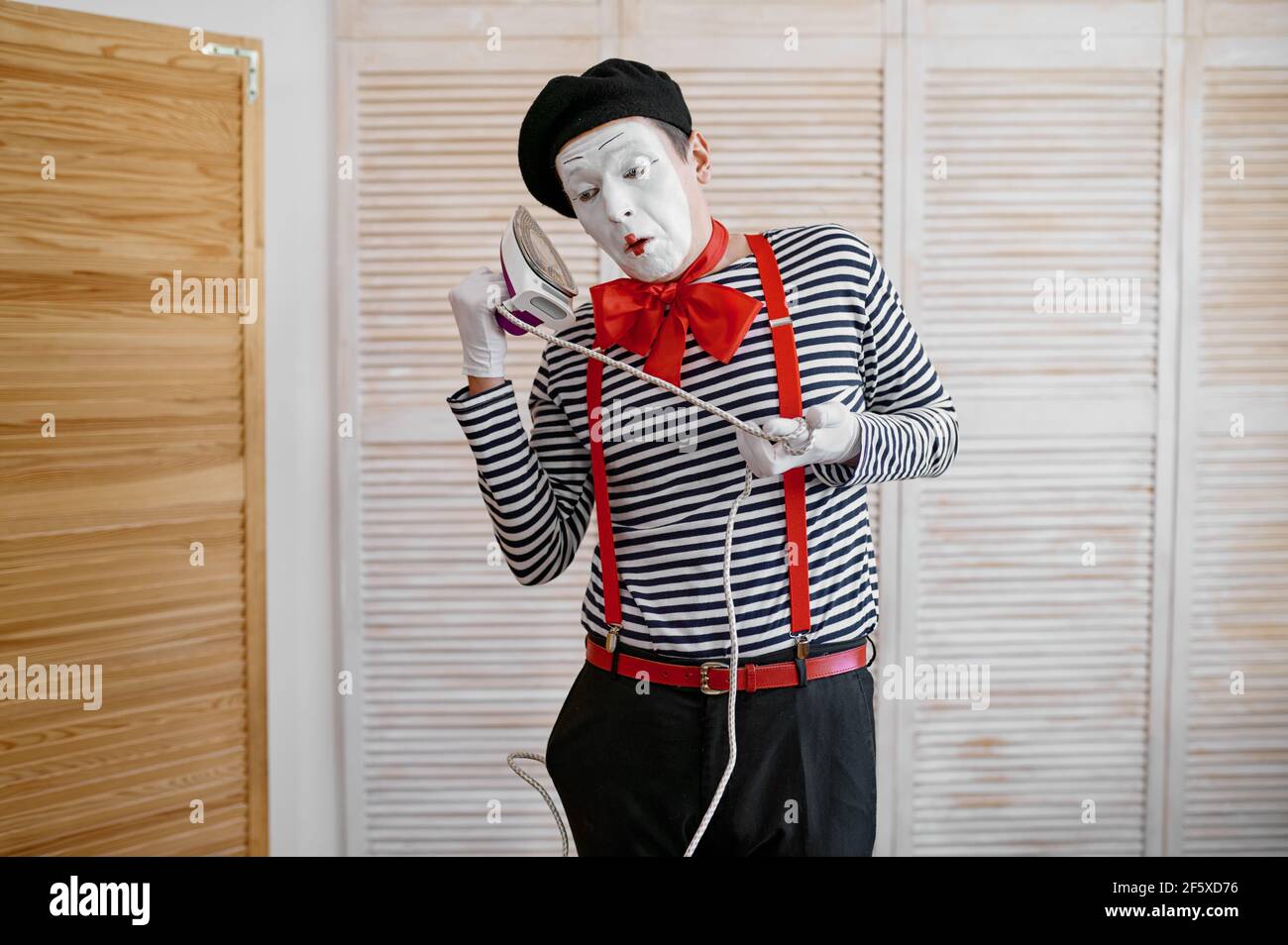 MIME artiste avec un fer à repasser, téléphone parody, comédie Banque D'Images
